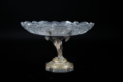 a glass bowl that is on a stand on a black background