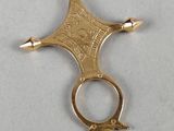 a close up of a small gold cross on a white surface