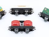 four toy trains are lined up in a circle on a white surface