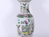 une photo d'un vase blanc et vert posé sur un socle en bois