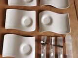 six assiettes et cuillères blanches posées sur une table