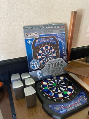 un jeu de fléchettes et une boîte de fléchettes posés sur un bureau