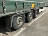 un semi-remorque vert garé sur le bord de la route