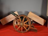 a wine bottle sitting on top of a wooden wheel