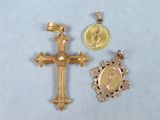 deux croix dorées et une médaille sur un fond blanc