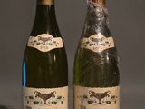 two bottles of wine sitting next to each other on a table