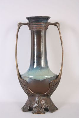 a vase that is sitting on a stand on a white surface
