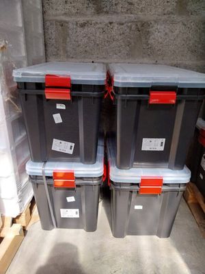 three plastic boxes with labels on them sitting on a pallet