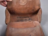 a hand that is holding a brown leather purse