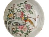 une assiette blanche décorée d'un oiseau et de fleurs