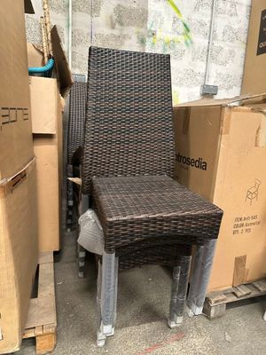 une chaise en osier posée au milieu d'une pile de cartons