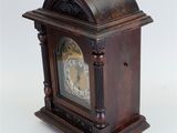 a wooden clock that is sitting on a white surface