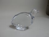a clear glass bird that is sitting on a table