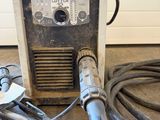 an image of a welder is sitting on the floor next to a hose