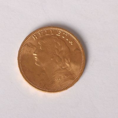a gold coin sitting on top of a white surface