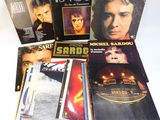 the album covers of michael sardou ' s album are stacked on top of each other