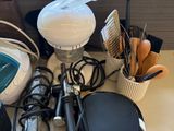 a table with a bunch of hair dryers on it