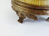 a gold and marble bowl on a stand on a white surface