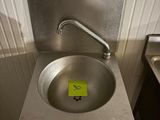 un lavabo sur lequel est collé un autocollant jaune, dans une salle de bains