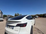 the rear end of a white tesla suv parked in a parking lot