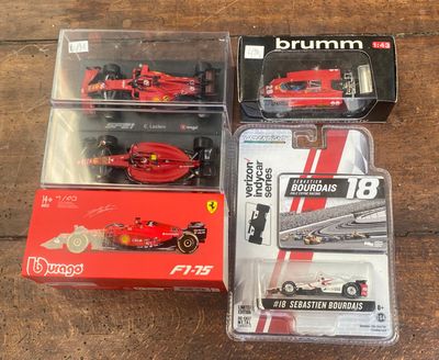 trois Ferrari emballées dans leurs boîtes, posées sur une table en bois