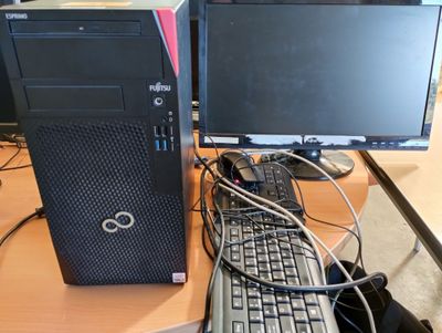 un ordinateur de bureau posé sur une table avec un clavier et un écran