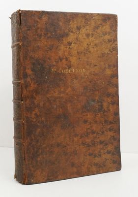 an old book with a brown cover sitting on top of a table