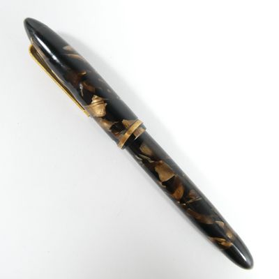 un gros plan d'un stylo sur une surface blanche avec un fond blanc