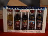 five bottles of alcohol in a box on a table