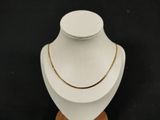 a close up of a necklace on a mannequin with a black background