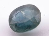 a close up of a blue sapphire stone on a white surface