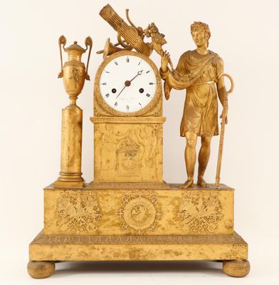 une horloge en or représentant un homme tenant un oiseau et un vase