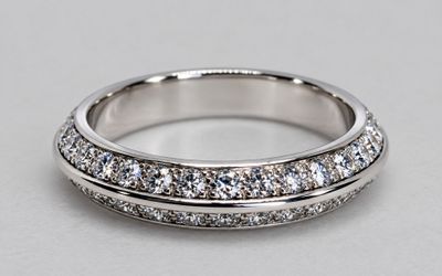 a close up of a wedding ring with diamonds on a table