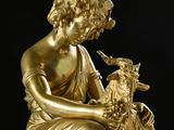 gold statue of a woman with a bird and a goat