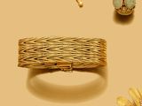 un bracelet, une bague et une broche en or sur fond jaune