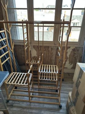 two wooden chairs sitting in a room with a window