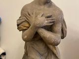 statue of a woman holding a baby in her arms on a wooden table