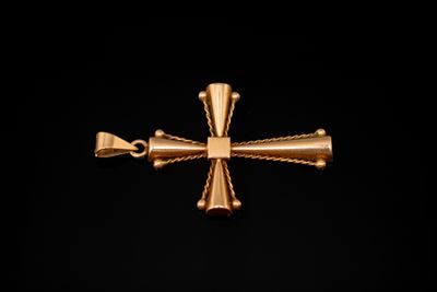 une image représentant une croix dorée sur fond noir