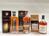 several bottles of different types of whiskey are lined up on a table