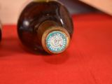 two bottles of wine sitting on a red cloth