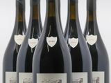 six bouteilles de vin sont alignées sur une surface blanche