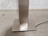 a metal table with a metal base on the floor