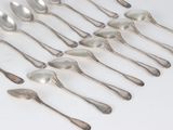 six silver spoons are arranged in a row on a white surface