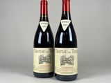 two bottles of red wine sitting next to each other on a table