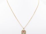 a gold necklace with a pink flower on a chain