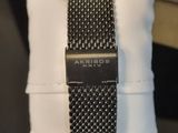 a black and white watch sitting on top of a pillow