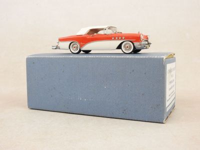 une petite voiture rouge et blanche posée sur une boîte bleue