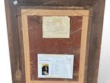 an old picture frame with a picture of a man and a plaque on it