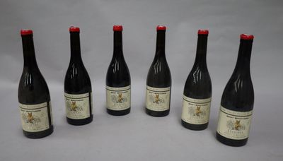 six bouteilles de vin sont alignées sur une table