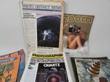 a lot of magazines and a camera on the table